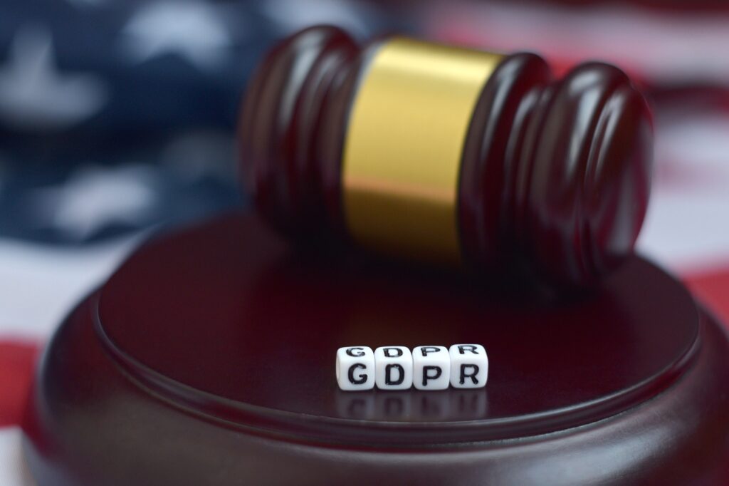 Justice mallet and GDPR acronym close up with US flag on background